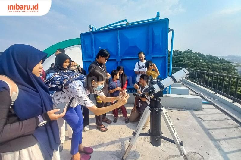 Para pengunjung sedang mengamati matahari menggunakan teleskop di Planetarium UIN Walisongo. (Inibaru.id/ Fitroh Nurikhsan)