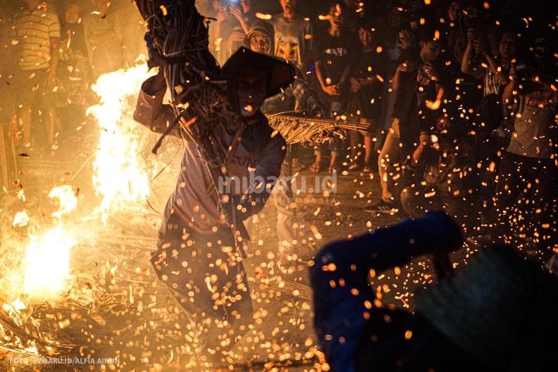 Percikan api yang khas dari blarak yang terbakar.