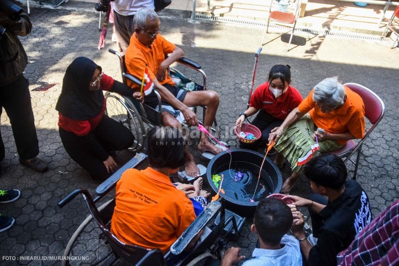 Petugas Panti Jompo Panti Wreda Pengayoman memberi semangat para penghuni panti yang sedang mengikuti lomba.