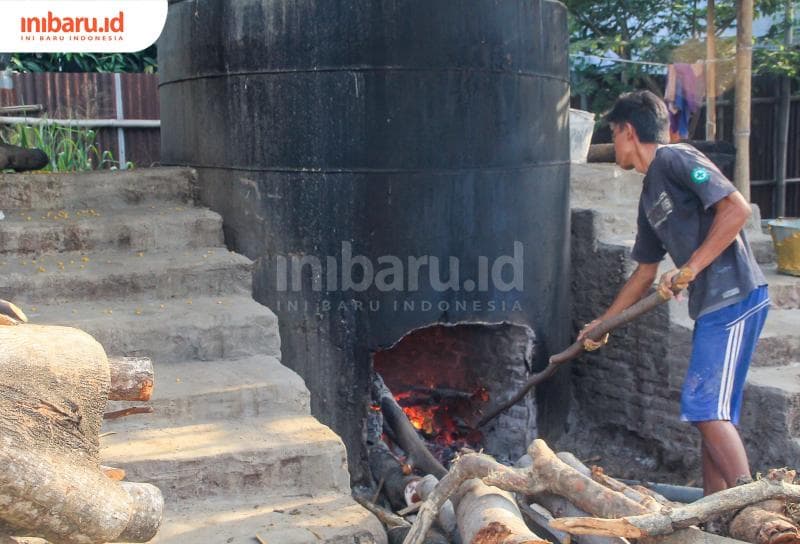 Yulianto, salah seorang pembuat marning&nbsp;tengah mengontrol api untuk merebus jagung sebelum dijemur. (Inibaru.id/ Imam Khanafi)